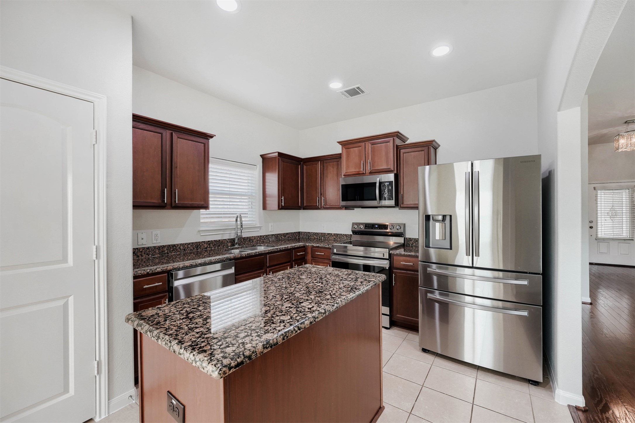 13408 Clara Martin Road Manor, TX 78653 - Photo 7 of 27 a kitchen with stainless steel appliances granite countertop a refrigerator stove and microwave