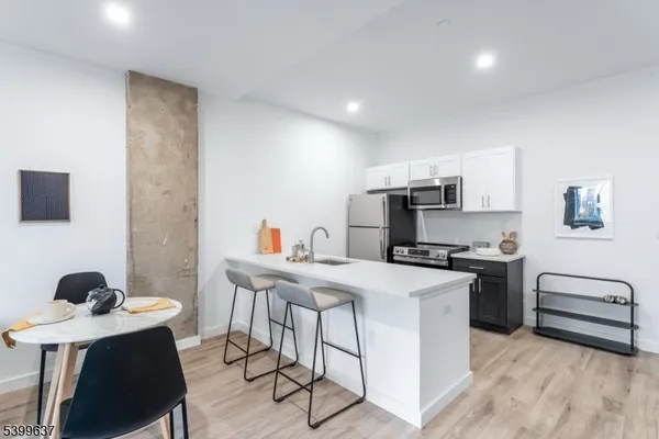 a kitchen with stainless steel appliances a stove a sink a microwave and a refrigerator