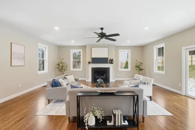 a living room with furniture a fireplace and wooden floor