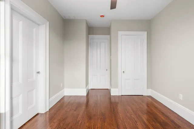 a view of an empty room with wooden floor