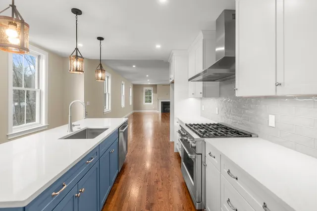 a kitchen with granite countertop a sink a counter space appliances and cabinets
