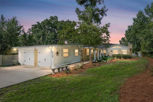 a view of a house with backyard and trees
