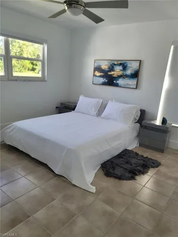 a bedroom with a bed and a painting on the wall