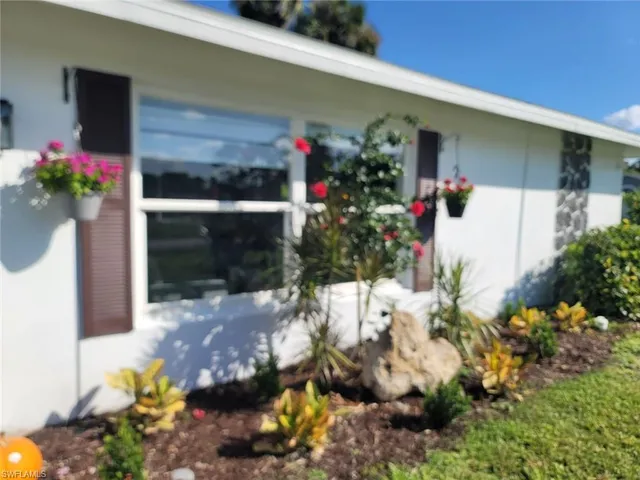 a front view of a house with a yard and flowers