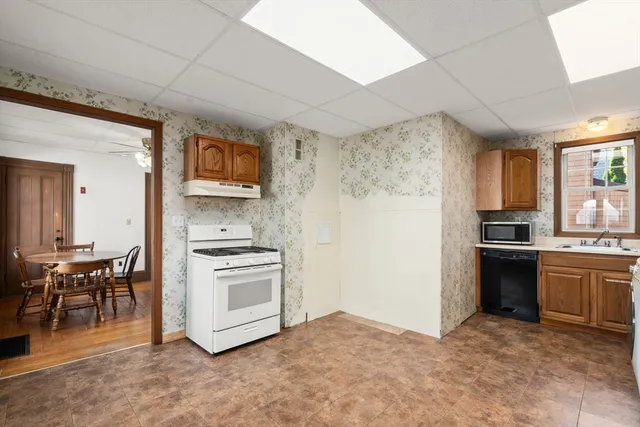 a kitchen with stainless steel appliances granite countertop a stove top oven a sink and a refrigerator