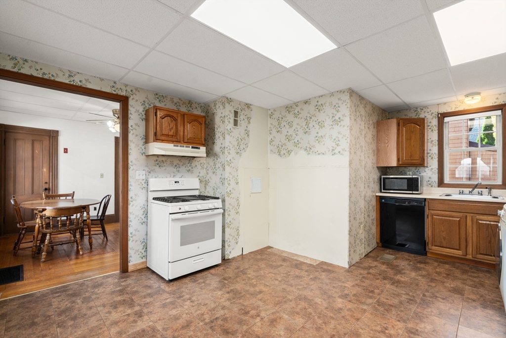 106 Norfolk Avenue Swampscott, MA 01907 - Photo 11 of 26 a kitchen with stainless steel appliances granite countertop a stove top oven a sink and a refrigerator