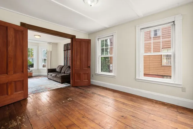 an entryway and livingroom with furniture wooden floor windows and a bedroom