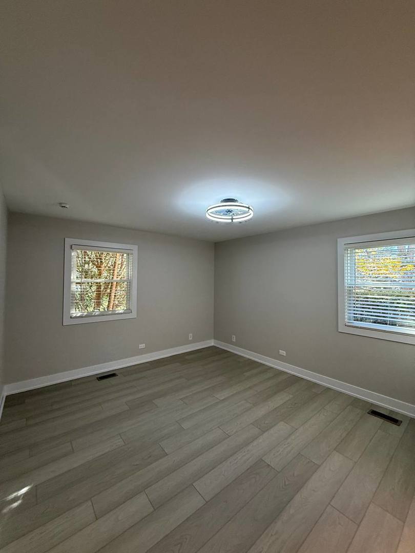 2403 Mallow Court, Unit Z1 Schaumburg, IL 60107 - Photo 13 of 17 an empty room with wooden floor and windows
