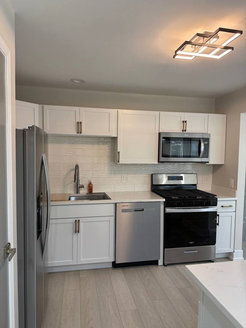 2403 Mallow Court, Unit Z1 Schaumburg, IL 60107 - Photo 5 of 17 a kitchen with stainless steel appliances a stove a microwave and white cabinets