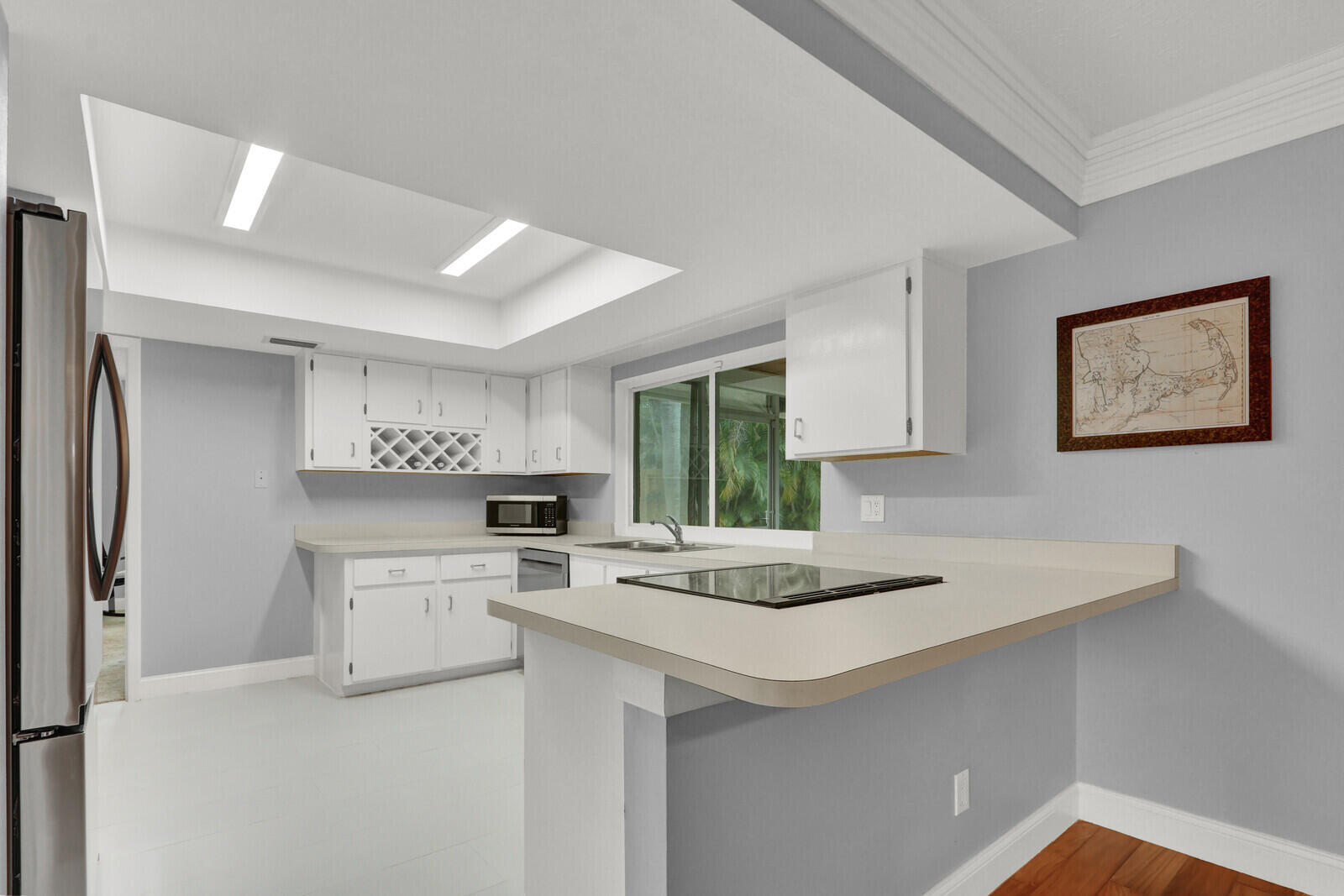 3035 Southeast Glasgow Drive Stuart, FL 34997 - Photo 14 of 52 a kitchen with stainless steel appliances a white table chairs and a refrigerator