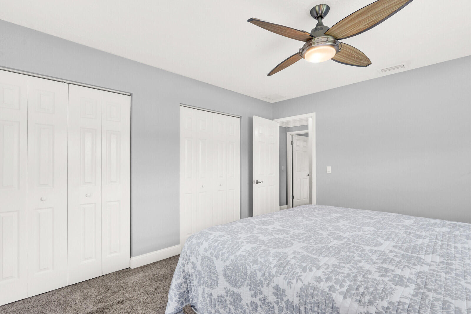 3035 Southeast Glasgow Drive Stuart, FL 34997 - Photo 26 of 52 a bedroom with a bed and a chandelier fan