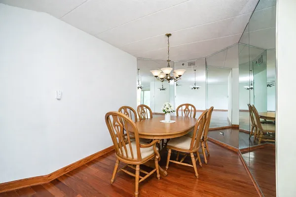 a view of a dining room with furniture wooden floor and chandelier