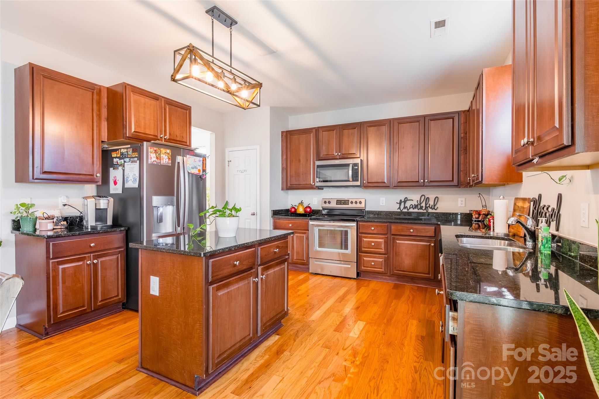 15127 Taylor Ridge Lane Charlotte, NC 28273 - Photo 13 of 42 a kitchen with stainless steel appliances granite countertop a stove top oven a sink dishwasher a dining table and chairs with wooden floor
