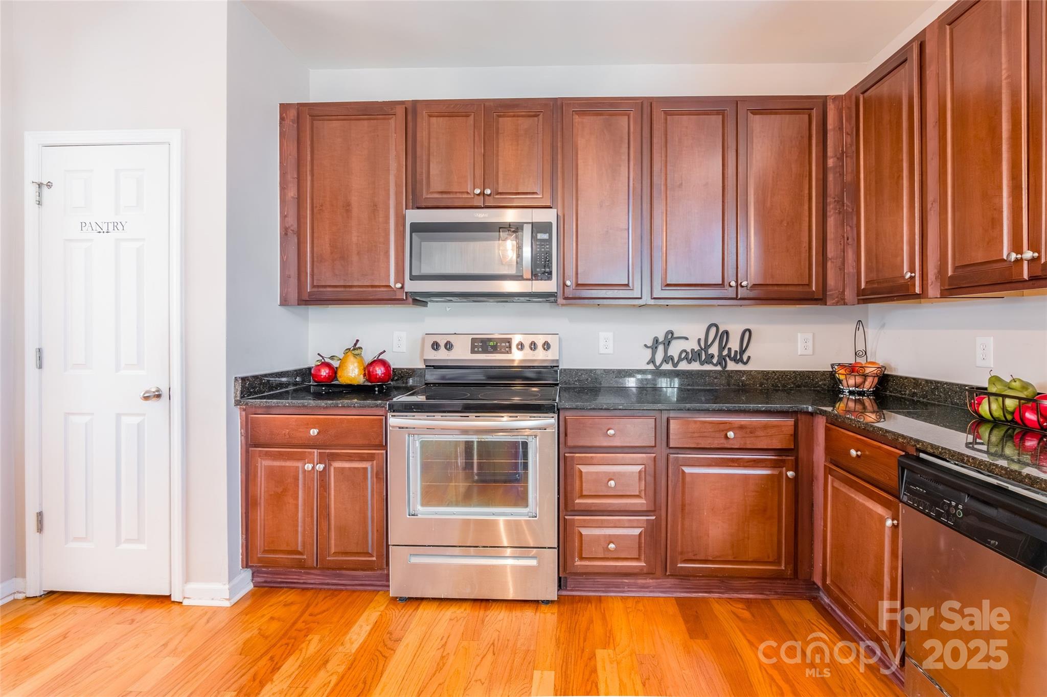 15127 Taylor Ridge Lane Charlotte, NC 28273 - Photo 15 of 42 a kitchen with granite countertop wooden cabinets a stove top oven a sink and dishwasher