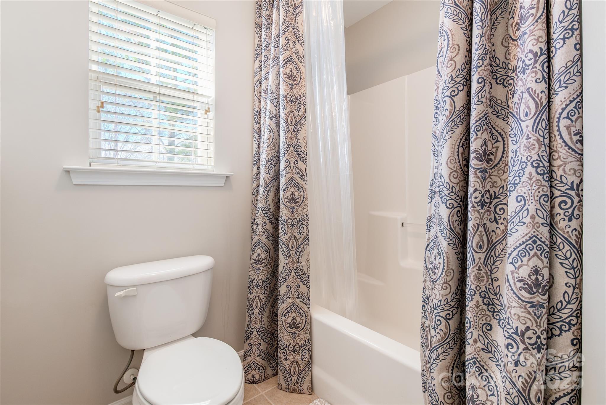 15127 Taylor Ridge Lane Charlotte, NC 28273 - Photo 35 of 42 a bathroom with a toilet and a shower curtain