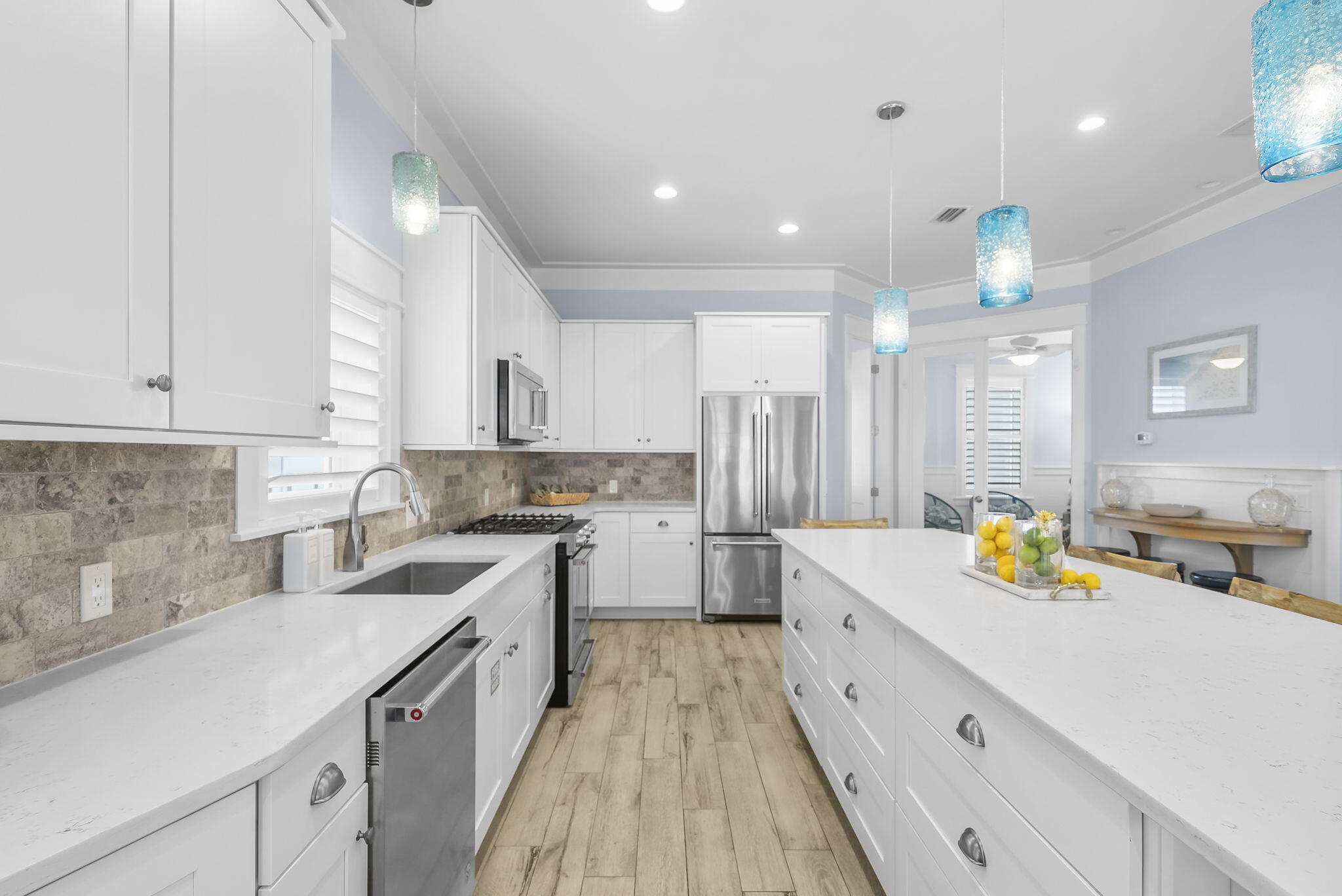 93 Emerald Cove Lane North Inlet Beach, FL 32461 - Photo 12 of 68 a large white kitchen with stainless steel appliances lots of counter space and wooden floor