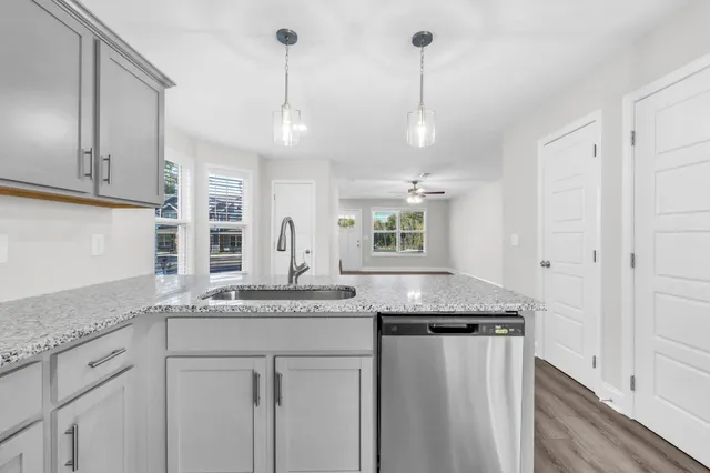 a kitchen with granite countertop kitchen island white cabinets and white appliances