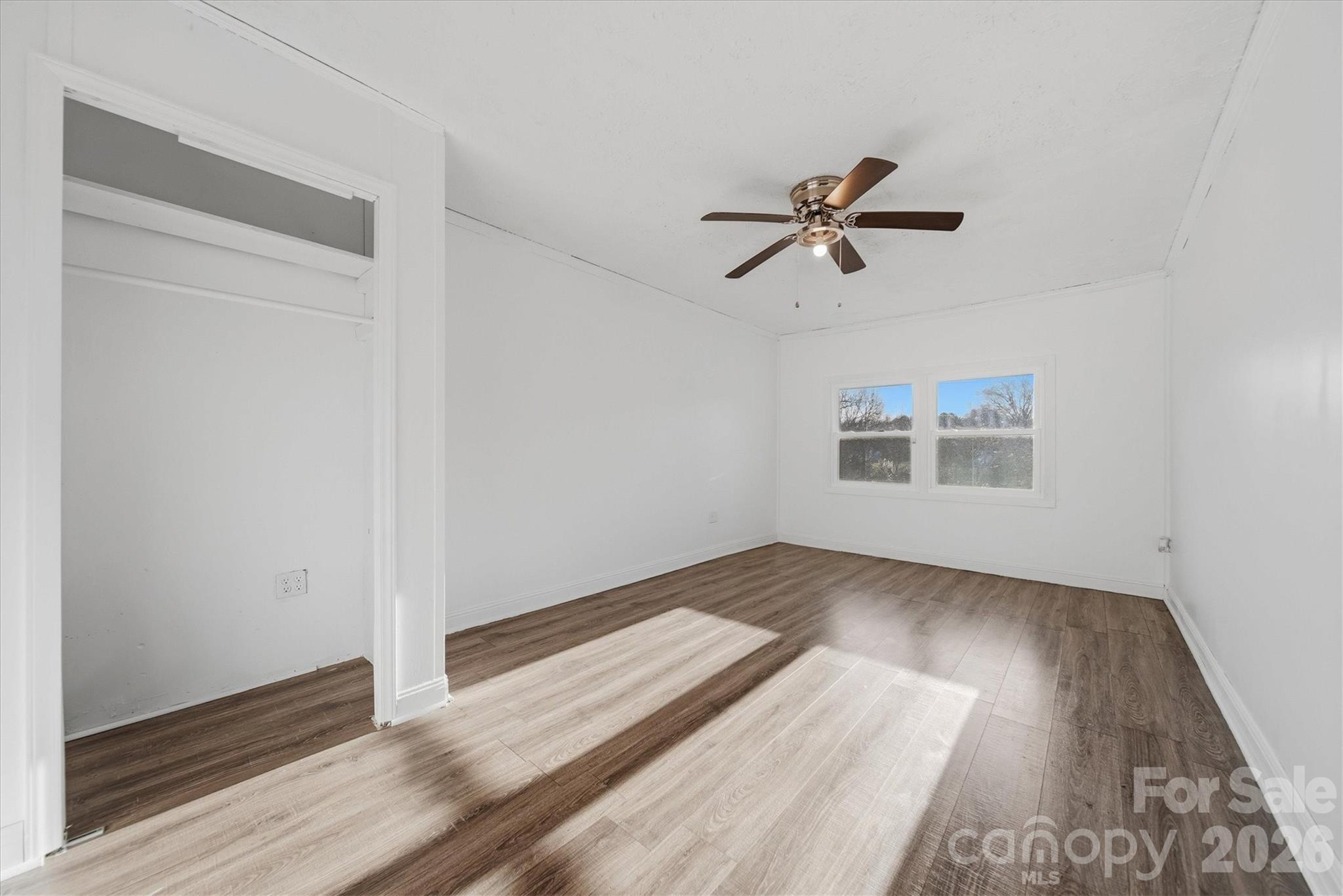 915 Airport Road Shelby, NC 28150 - Photo 16 of 37 an empty room with wooden floor ceiling fan and window