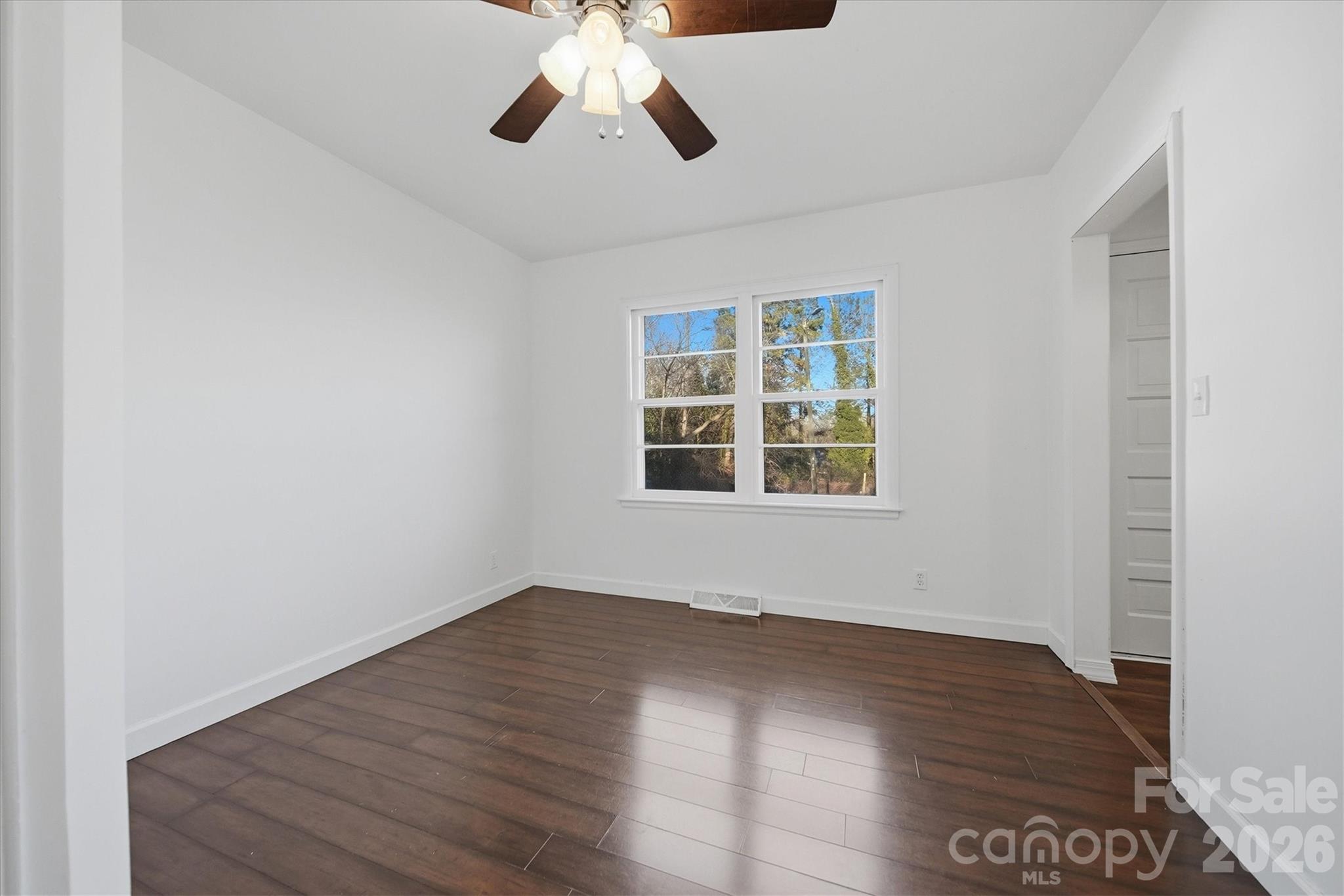 915 Airport Road Shelby, NC 28150 - Photo 18 of 37 an empty room with wooden floor chandelier fan and windows