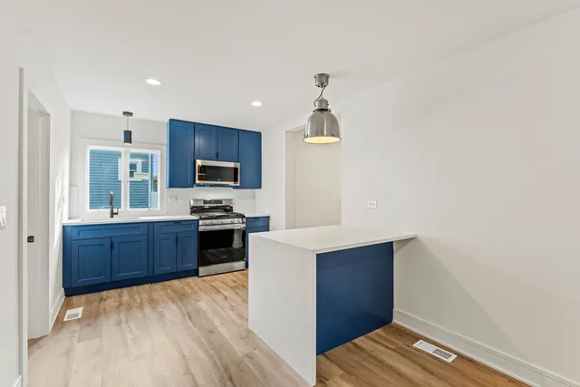 a kitchen with stainless steel appliances a refrigerator and a stove top oven