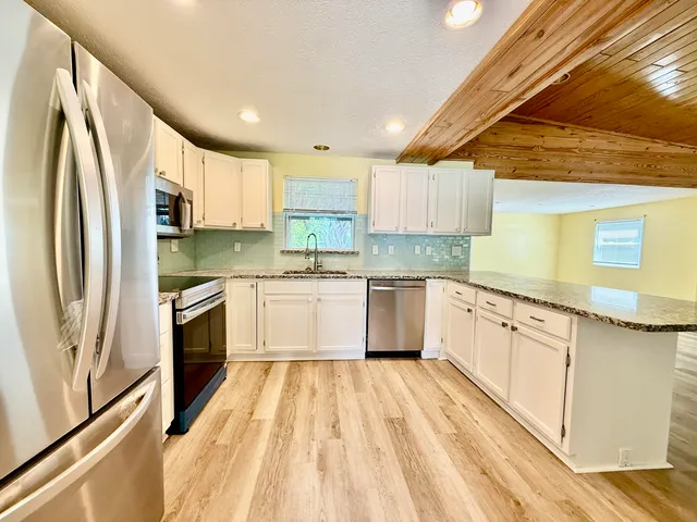 a kitchen with stainless steel appliances a sink cabinets and a refrigerator