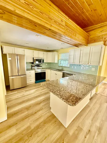 a kitchen with stainless steel appliances granite countertop a sink stove and refrigerator
