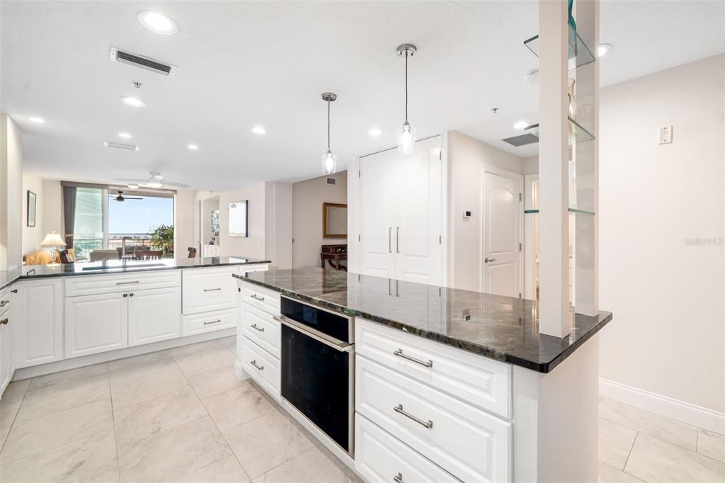 610 Riviera Dunes Way, Unit 503 Palmetto, FL 34221 - Photo 18 of 58 a large kitchen with granite countertop a stove a sink dishwasher and a refrigerator