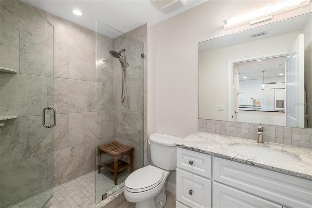 610 Riviera Dunes Way, Unit 503 Palmetto, FL 34221 - Photo 38 of 58 a bathroom with a granite countertop toilet a sink and a shower