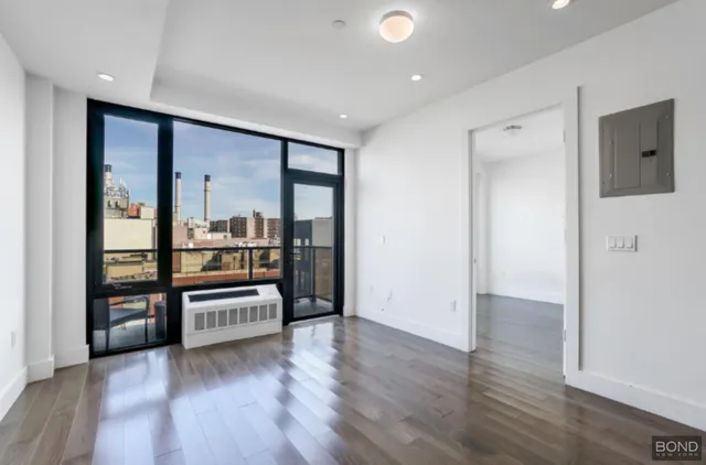 wooden floor in an empty room with a kitchen
