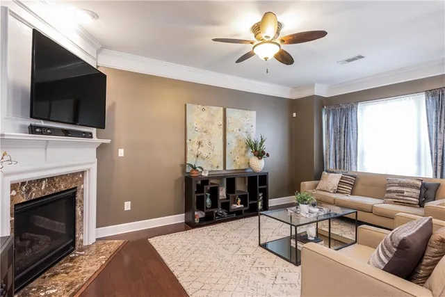 a living room with furniture a flat screen tv and a fireplace