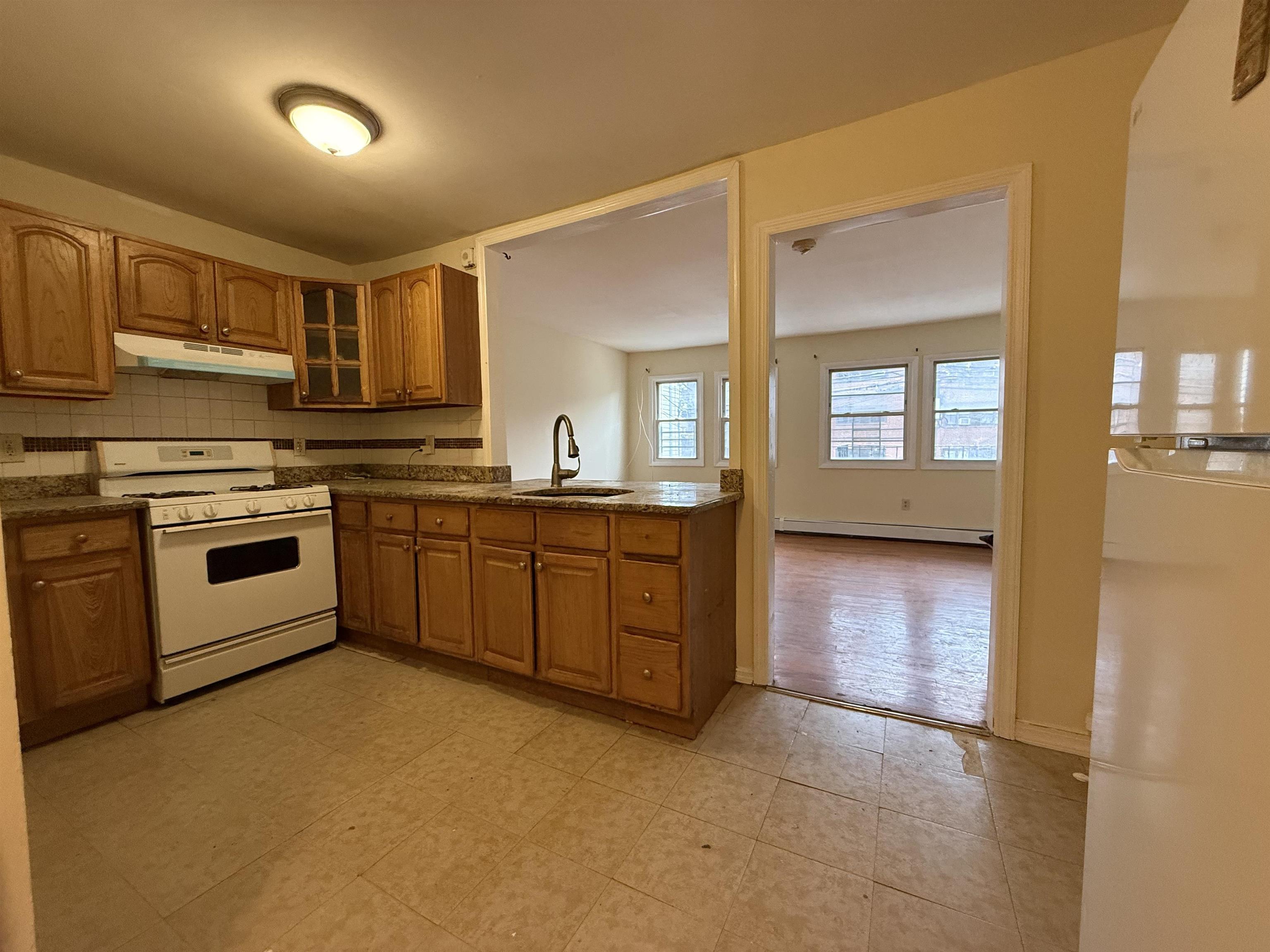 20 Dales Avenue, Unit 1 Jersey City, NJ 07306 - Photo 2 of 15 a kitchen with stainless steel appliances granite countertop a stove a sink and a refrigerator