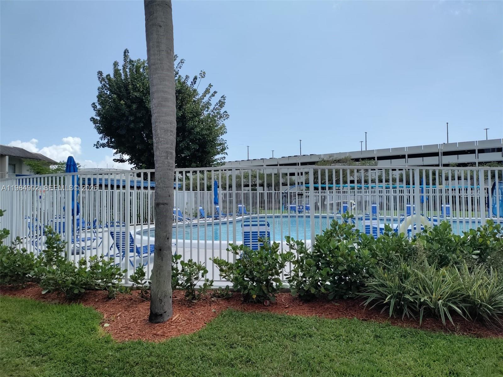 7340 Southwest 82nd Street, Unit C205 Miami, FL 33143 - Photo 24 of 34 a view of a garden with a fence