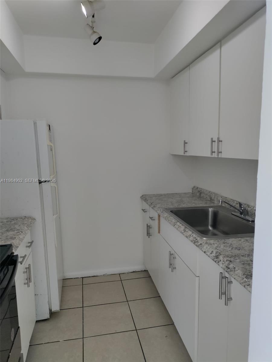7340 Southwest 82nd Street, Unit C205 Miami, FL 33143 - Photo 3 of 34 a kitchen with a sink and cabinets