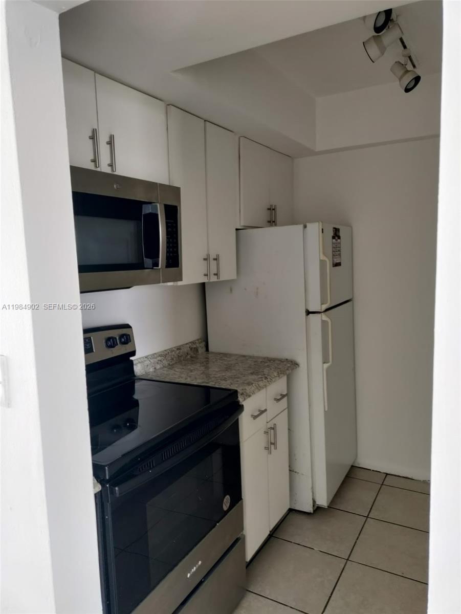 7340 Southwest 82nd Street, Unit C205 Miami, FL 33143 - Photo 5 of 34 a kitchen with stainless steel appliances a stove microwave and refrigerator