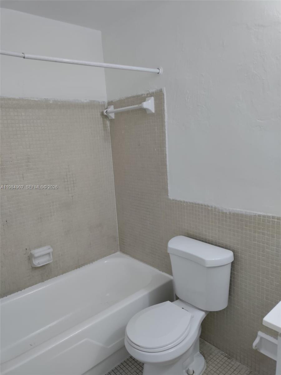 7340 Southwest 82nd Street, Unit C205 Miami, FL 33143 - Photo 8 of 34 a white toilet sitting next to a bath tub