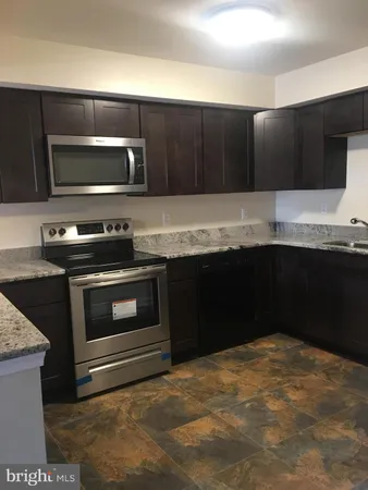 a kitchen with stainless steel appliances wooden cabinets and a sink