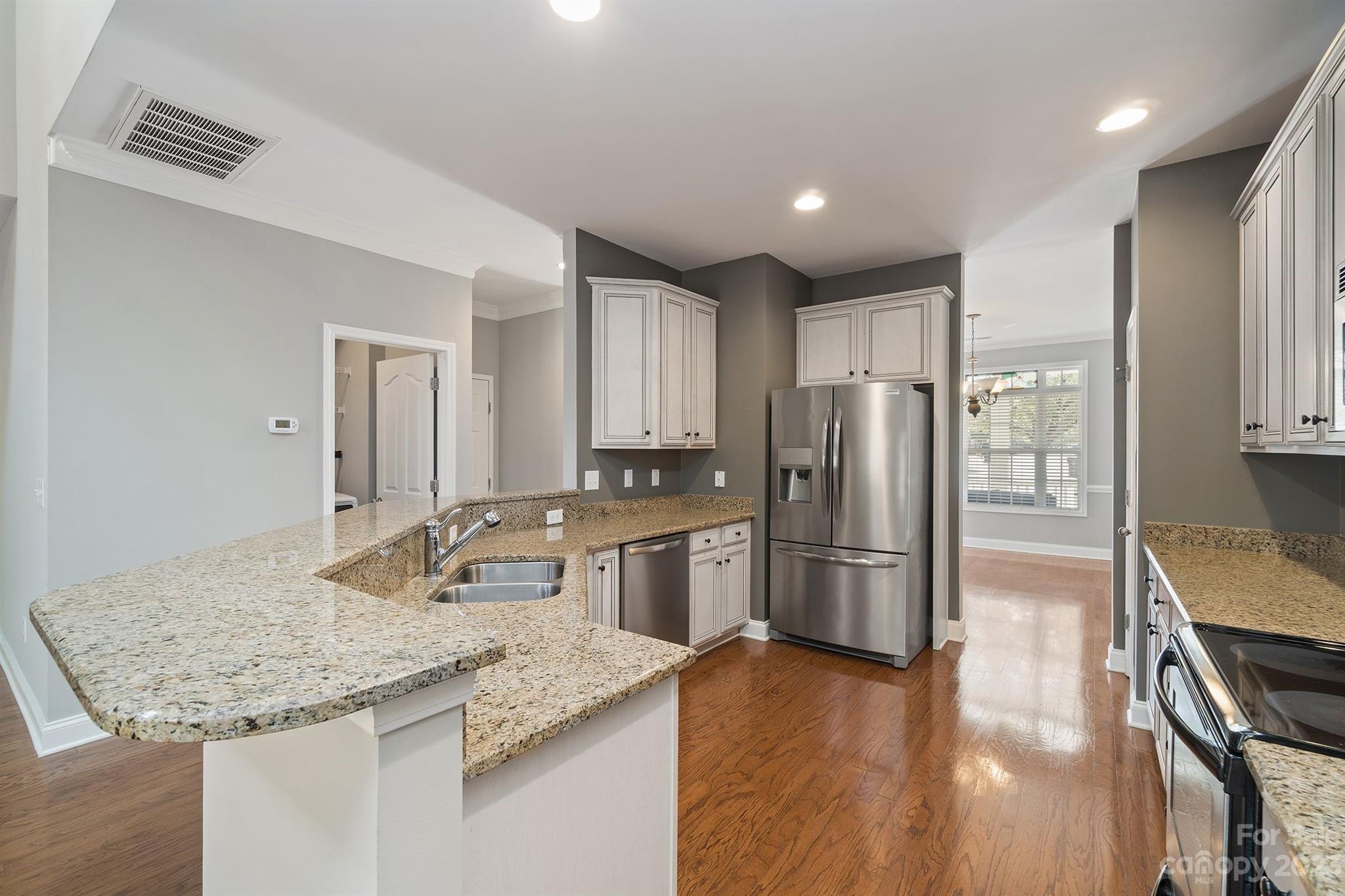 20232 Middletown Road Cornelius, NC 28031 - Photo 11 of 40 a kitchen with a refrigerator a sink and wooden cabinets