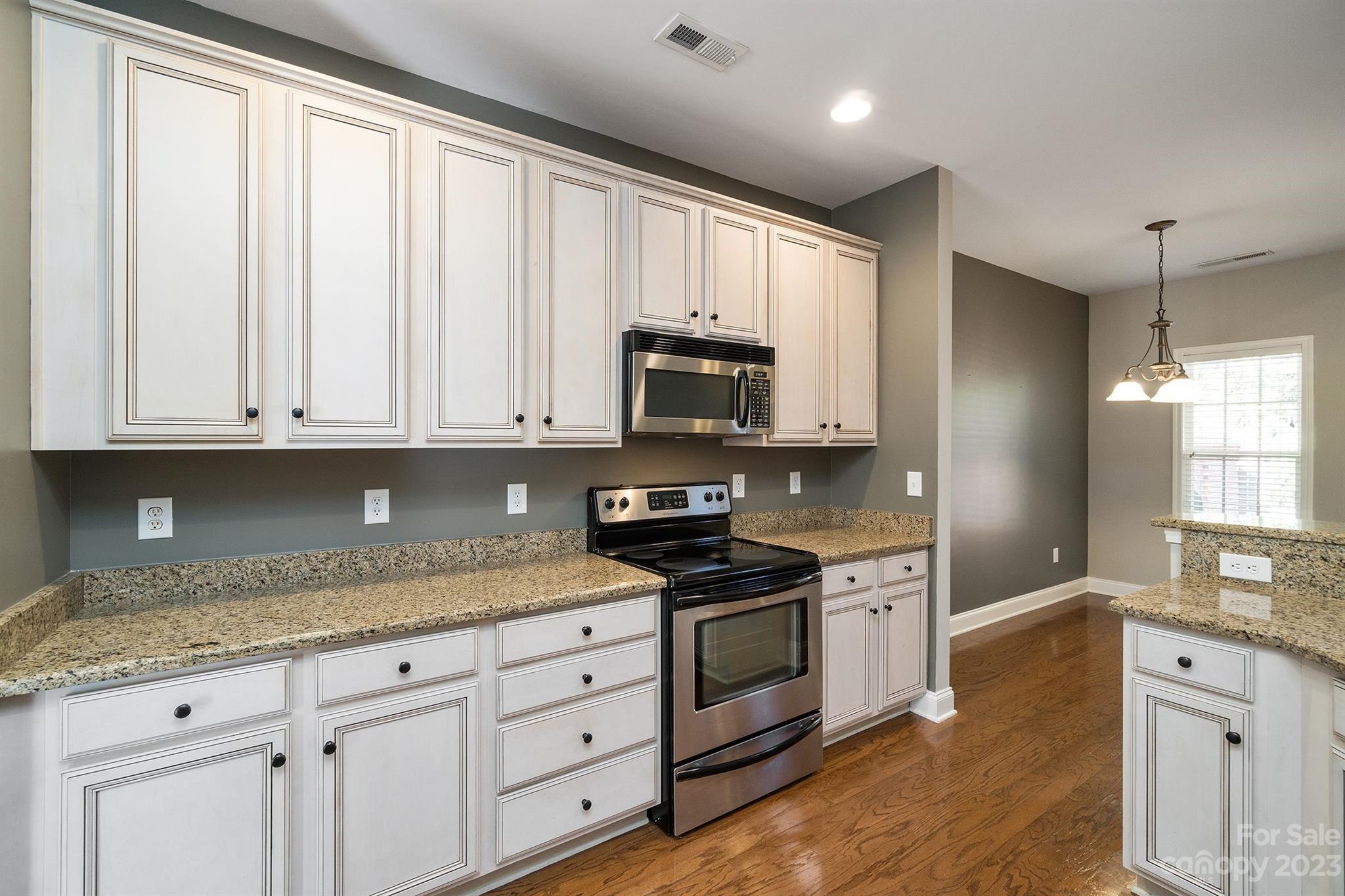 20232 Middletown Road Cornelius, NC 28031 - Photo 12 of 40 a kitchen with granite countertop white cabinets and stainless steel appliances