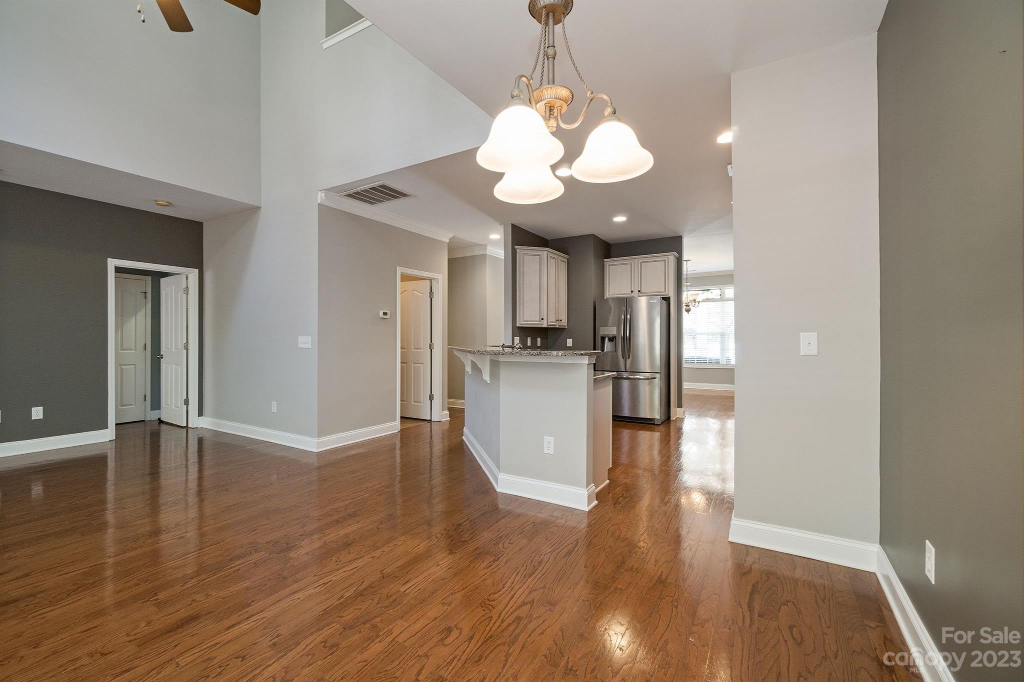 20232 Middletown Road Cornelius, NC 28031 - Photo 17 of 40 a view of a kitchen with a refrigerator wooden floor and a ceiling fan
