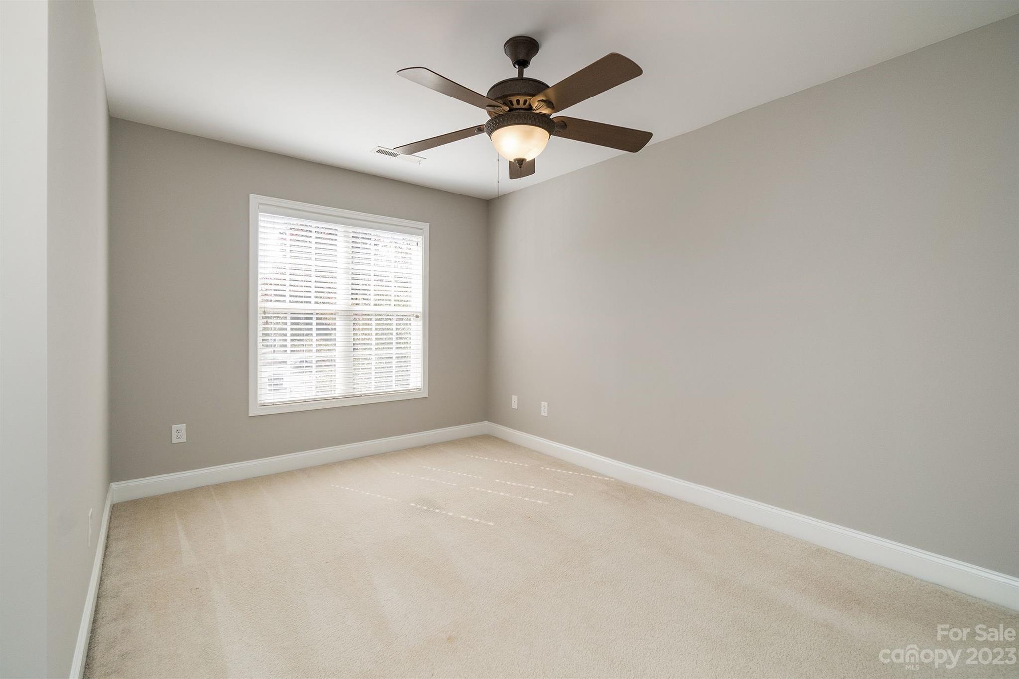 20232 Middletown Road Cornelius, NC 28031 - Photo 34 of 40 an empty room with chandelier fan and windows
