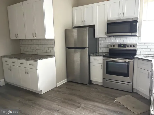 a kitchen with white cabinets and stainless steel appliances