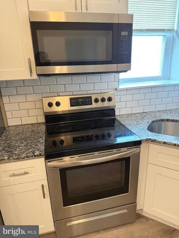 a stove top oven sitting inside of a kitchen