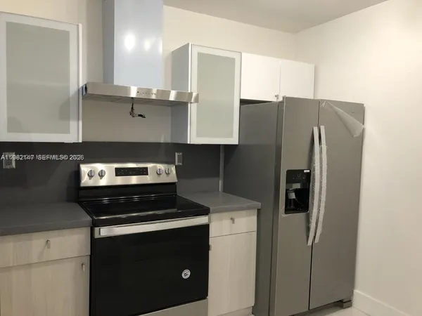a kitchen with a refrigerator and a stove