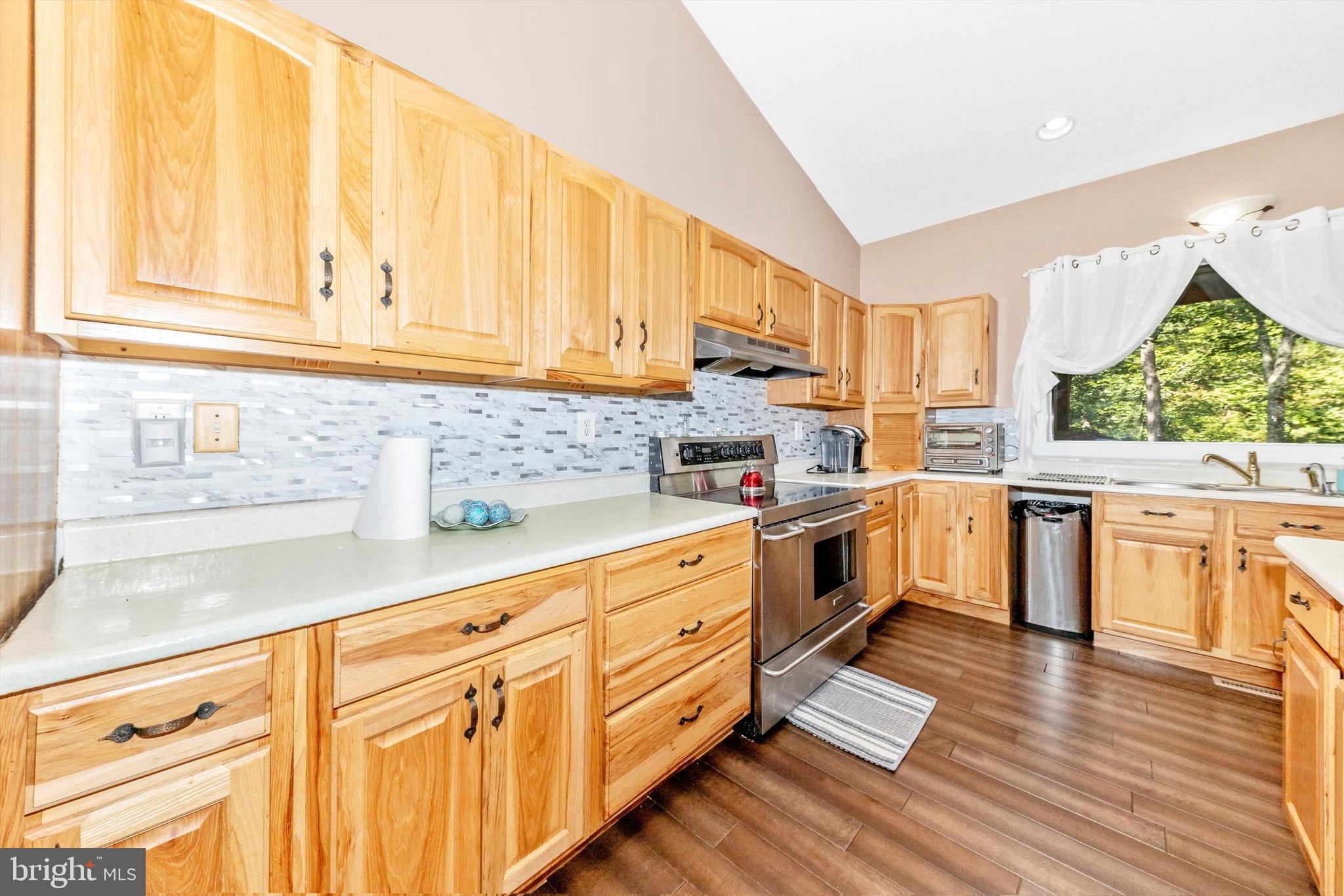 13450 Millstone Circle Hancock, MD 21750 - Photo 11 of 61 a kitchen with stainless steel appliances granite countertop a stove a sink and white cabinets with wooden floor