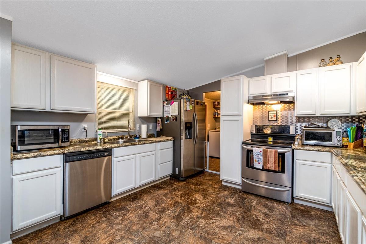 1861 Navigation Point Goodview, VA 24095 - Photo 8 of 26 a kitchen with stainless steel appliances granite countertop a stove a sink and a refrigerator