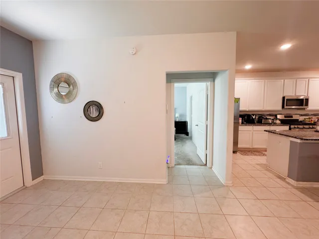 a large white room with a large mirror and a sink