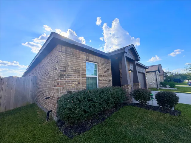 a view of a house with brick walls and a yard