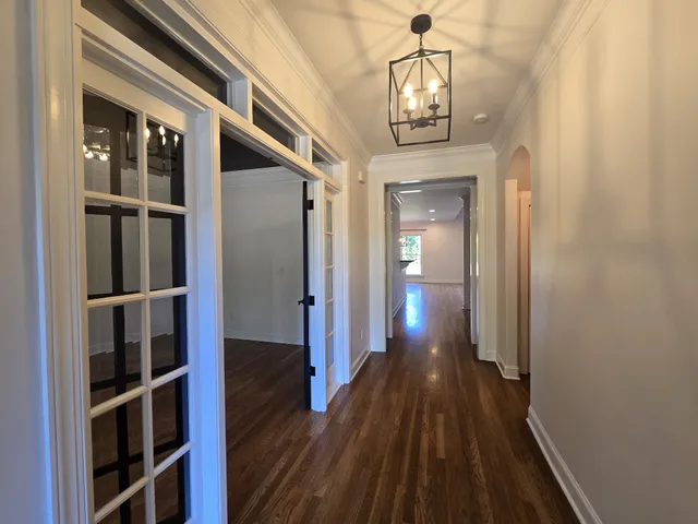 a view of a hallway with wooden floor and staircase
