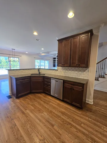 a large kitchen with wooden floors and wooden cabinets