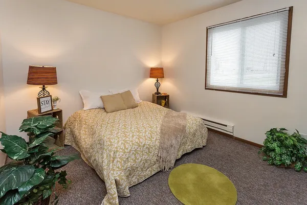 a bedroom with a bed and a potted plant